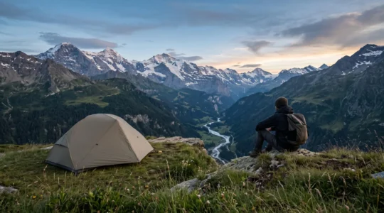 Tente légère de bivouac installée au crépuscule dans un paysage de montagne européen préservé