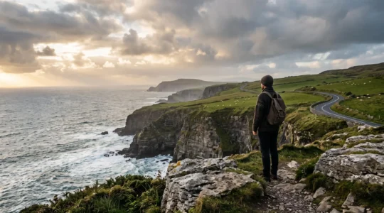 Voyageur contemplant les falaises spectaculaires de la côte atlantique irlandaise au coucher du soleil lors d'un road trip